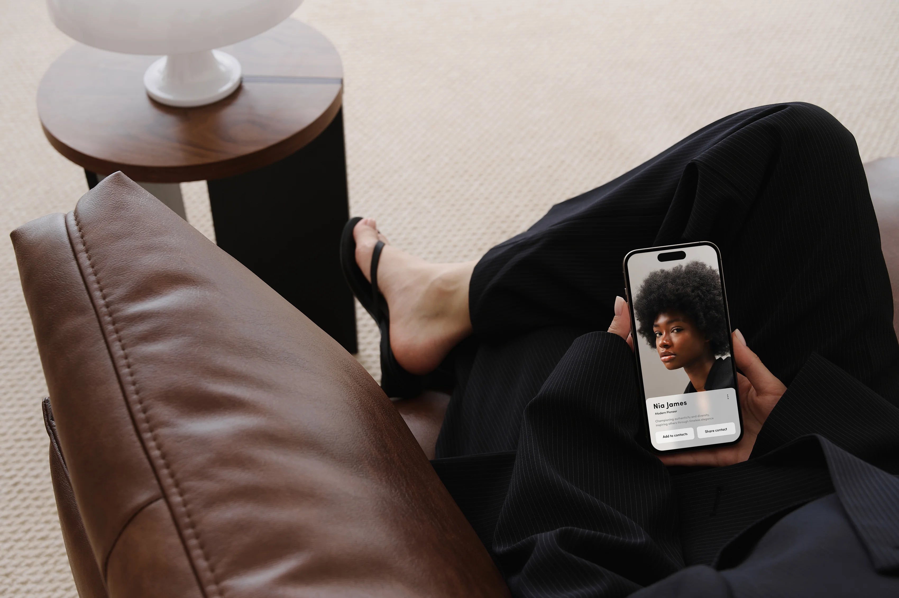 Sitting women holding a phone displaying a swapp business card